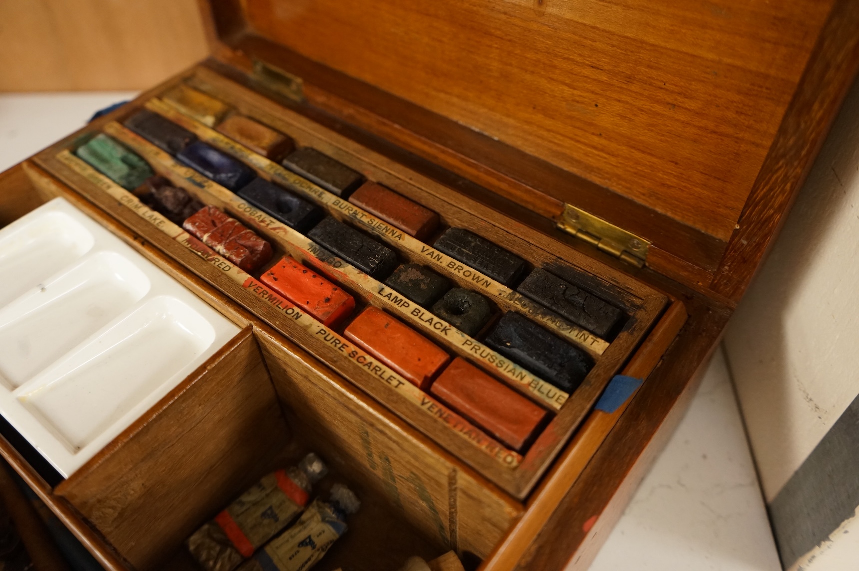 A 20th century Reeves and Sons Ltd artists box with ceramic palette and the remains of paint, 25cm wide